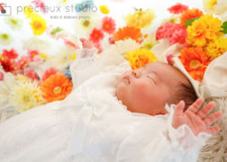 お花と寝ている赤ちゃんのお宮参り記念写真