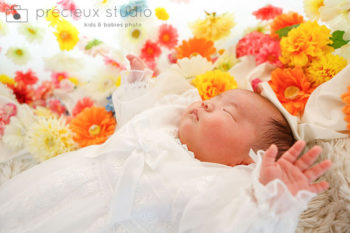 お花と寝ている赤ちゃんのお宮参り記念写真