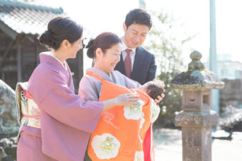 お宮参りの出張撮影写真 お父さんお母さんとおばあちゃんと掛け着を着せた赤ちゃん