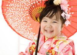 ピンクの着物に和傘で笑顔の七五三写真撮影