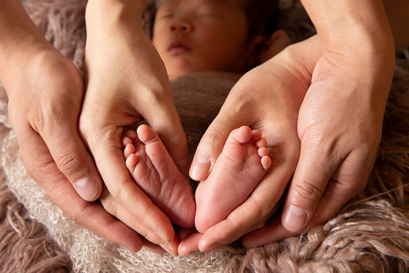 ニューボーンフォト撮影 赤ちゃんと足と両親の手のアップ