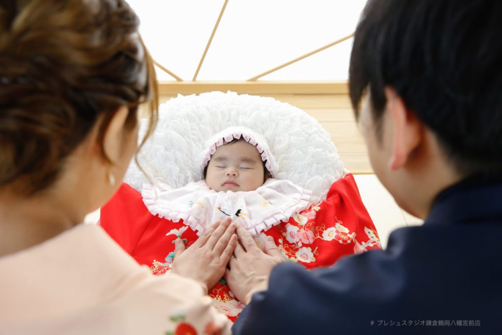 お宮参りの赤ちゃんと両親の後ろ姿