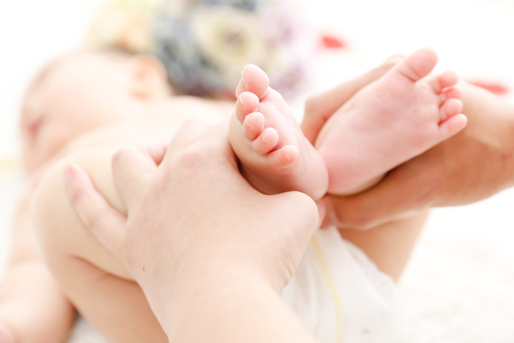 赤ちゃんの小さな足とママの手のアップ