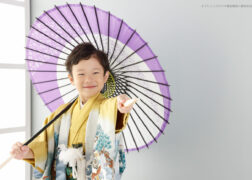 5歳の七五三記念写真撮影 黄色にグレーの羽織袴に和傘と扇子でポーズ