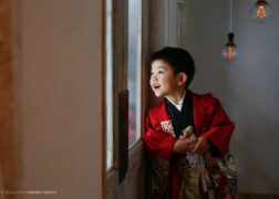 赤い羽織袴で5歳の七五三記念写真撮影 楽しそうな横顔