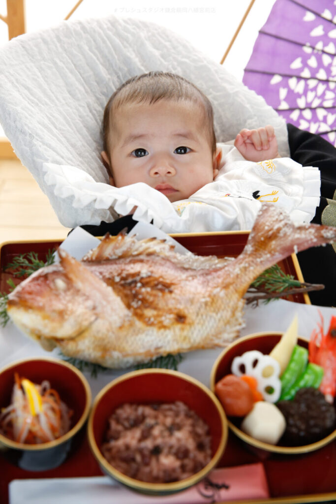 尾頭付きの鯛が載った祝い膳と一緒にお食い初めの写真撮影 生後3ヶ月の赤ちゃん