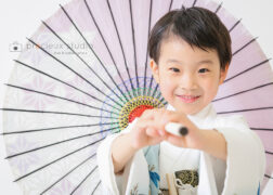 男の子の5歳の七五三記念写真撮影 白の羽織袴に和傘でポーズ
