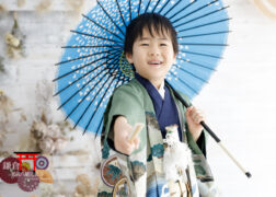 青い和傘を差して5歳の七五三記念写真撮影 緑の羽織袴