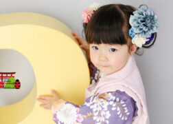 3歳の七五三記念写真撮影 紫の被布でお花の髪飾りの女の子