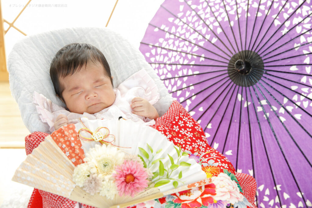 扇子プロップスと和傘と一緒にお宮参りの写真撮影の女の子