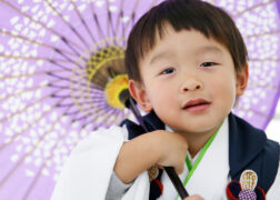 和傘を持って白い着物で3歳の七五三写真撮影