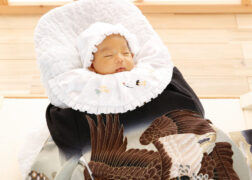 お宮参りの記念写真の赤ちゃん 祝い着に包まれてすやすやの寝姿