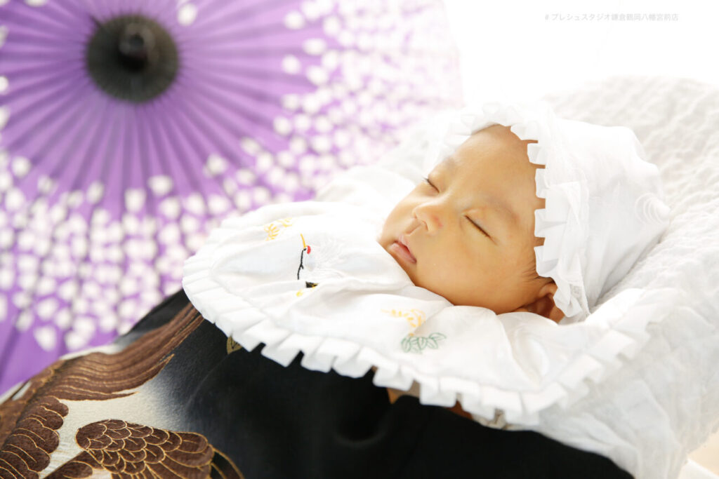 お宮参りの赤ちゃん 黒の掛け着と和傘で記念写真撮影