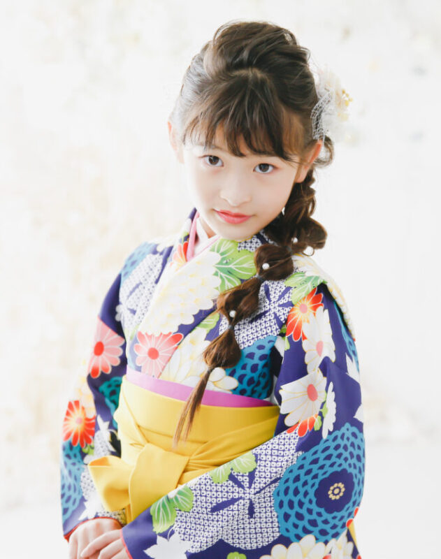 モダンな青にからし色の袴で小学生の記念行事写真撮影 編みおろし玉ねぎヘアアレンジの女の子