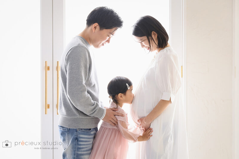 家族3人でマタニティフォト撮影 ママのおなかにキスするお姉ちゃん