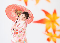 紅葉のセットで和傘をさして3歳の七五三写真撮影の女の子