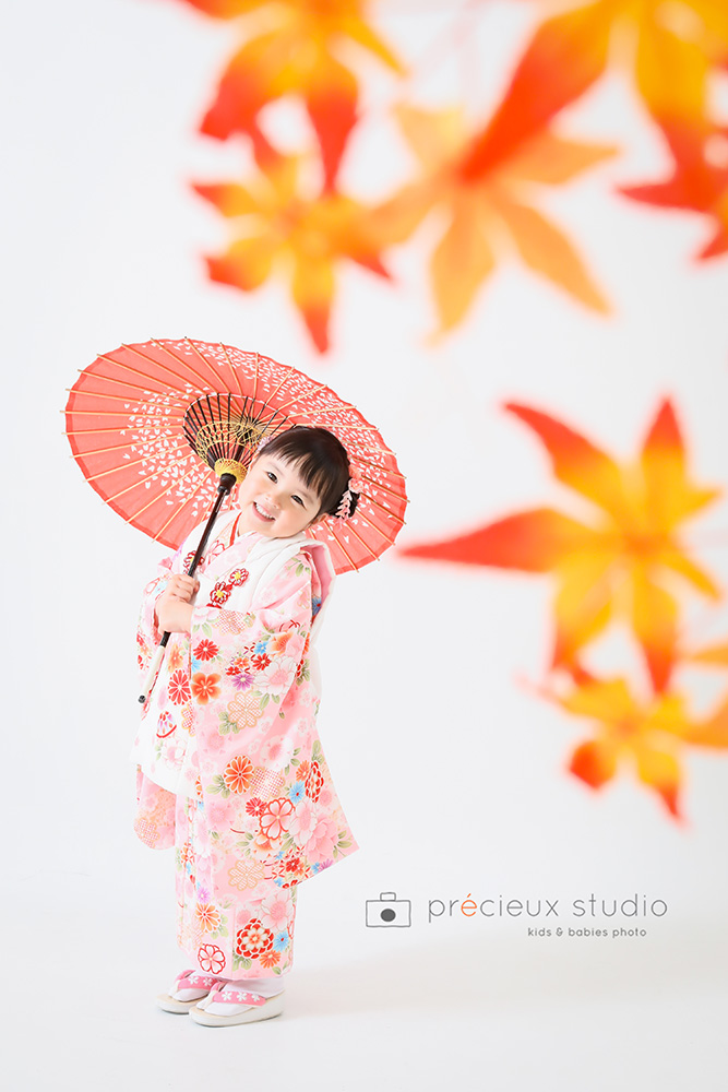 紅葉のセットで和傘をさして3歳の七五三写真撮影の女の子