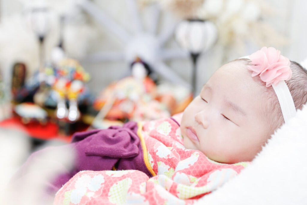初節句の赤ちゃんの寝姿 寝ている赤ちゃんの横顔とひな人形