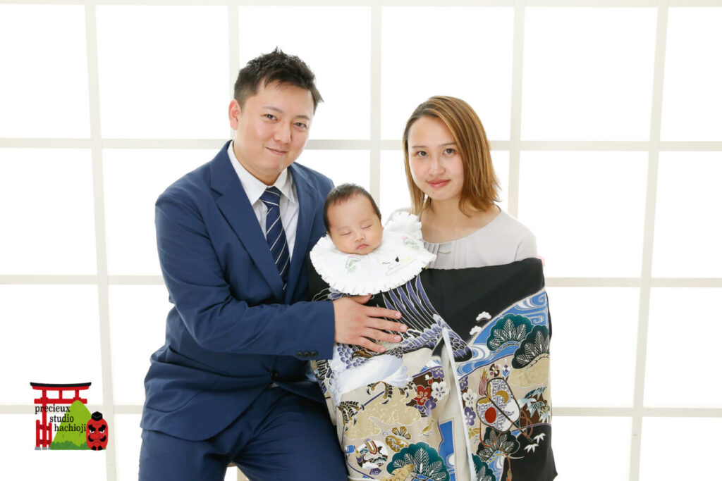 家族でお宮参りの記念写真撮影 黒い掛け着・のしめの赤ちゃんとママとパパ