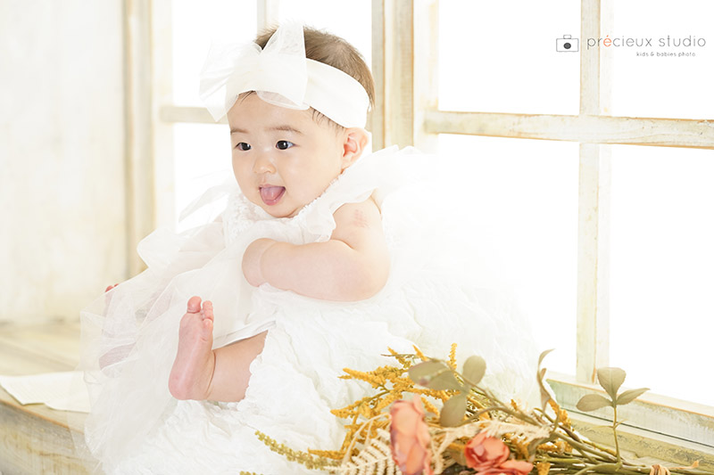 生後6か月の女の子のハーフバースデーフォト 白いベビードレスとヘッドドレス