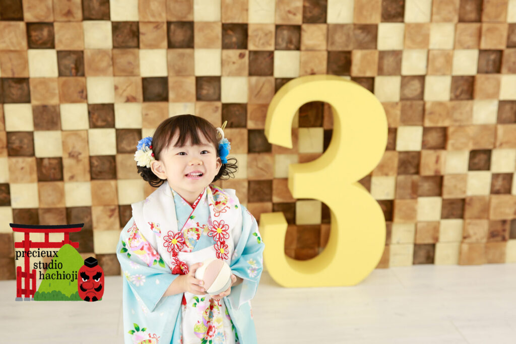3歳の七五三写真撮影 3のブロックと一緒に写る水色の被布の女の子