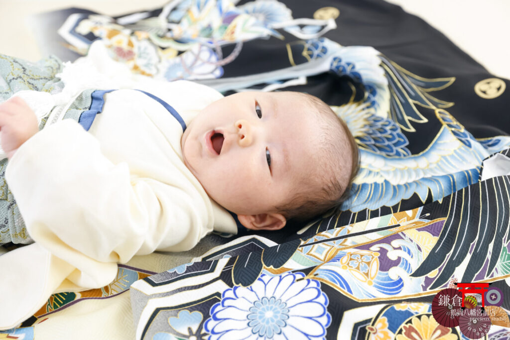男の子のお宮参り記念写真撮影 黒と青の祝い着に寝転ぶ赤ちゃん