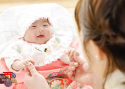 ほほえむ赤ちゃんとママの後ろ姿 お宮参りの記念写真撮影