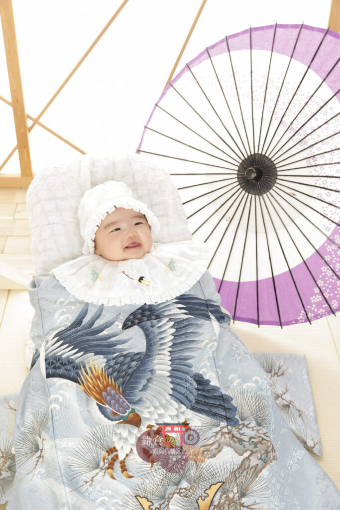 男の子のお宮参り記念写真撮影 ブルー系の祝い着に帽子とよだれかけで正装の赤ちゃん