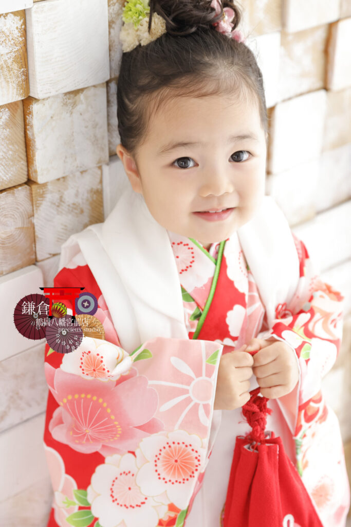 3歳の七五三記念写真撮影の女の子 白に赤の被布でにっこり笑顔