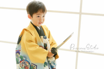 山吹色の羽織袴で刀を構えてポーズの男の子 七五三記念写真撮影