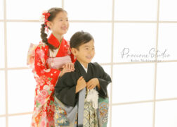 姉弟で七五三の記念写真撮影 赤い着物のお姉ちゃんと黒い羽織袴の弟