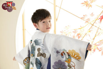白い羽織袴で七五三の記念写真撮影 和室セットで振り向きポーズの男の子