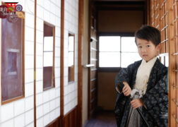 レトロな障子の前で七五三記念写真撮影 モノトーンの羽織袴で刀を構える5歳の男の子