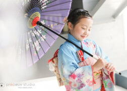 水色の着物で7歳の七五三記念写真撮影の女の子 和傘を持ってポーズ