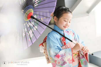 水色の着物で7歳の七五三記念写真撮影の女の子 和傘を持ってポーズ