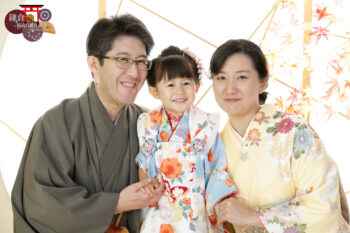 家族で着物姿の七五三写真撮影 水色のモダンな被布の3歳の女の子とママとパパ