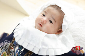 お宮参りの記念写真 掛け着・大黒帽子によだれかけで正装の男の子