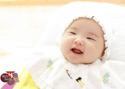 お宮参りの記念写真撮影 大黒帽子とよだれかけの赤ちゃん