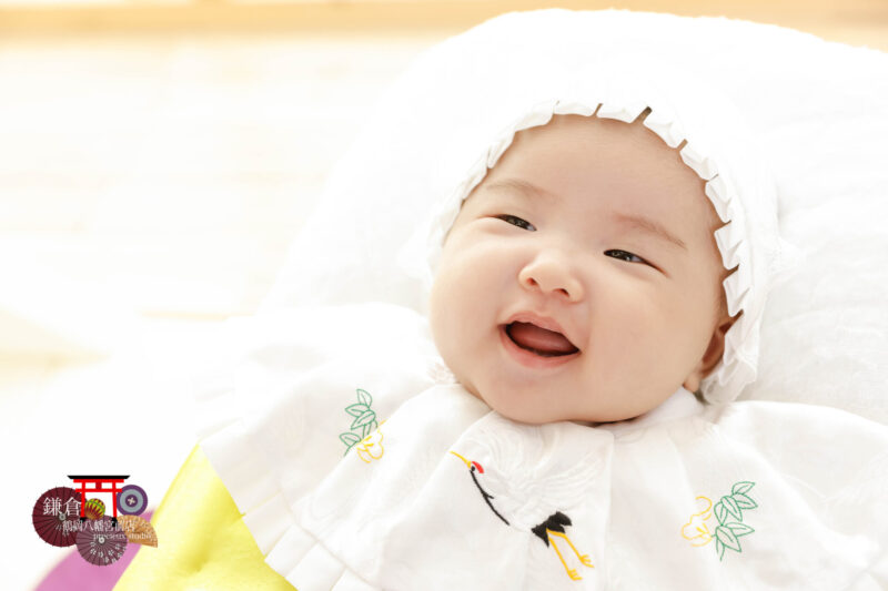 お宮参りの記念写真撮影 大黒帽子とよだれかけの赤ちゃん