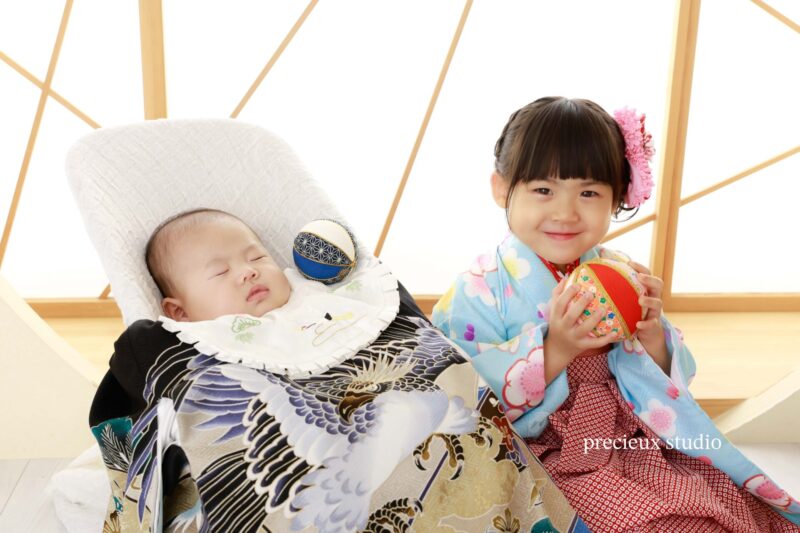 お姉ちゃんと一緒にお宮参りの記念写真撮影 祝い着を掛けた男の子