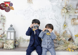 おしゃれなスーツに黄色の蝶ネクタイで七五三写真撮影 カメラを構える兄弟