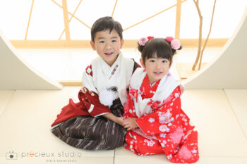 赤い着物で七五三写真撮影 和室で妹と手をつなぐお兄ちゃん