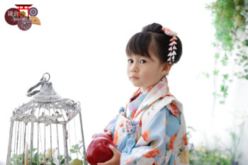 モダンな水色とオレンジの被布で3歳の七五三記念写真撮影の女の子