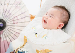 お宮参りの記念写真撮影 祝い着姿で笑顔の赤ちゃん