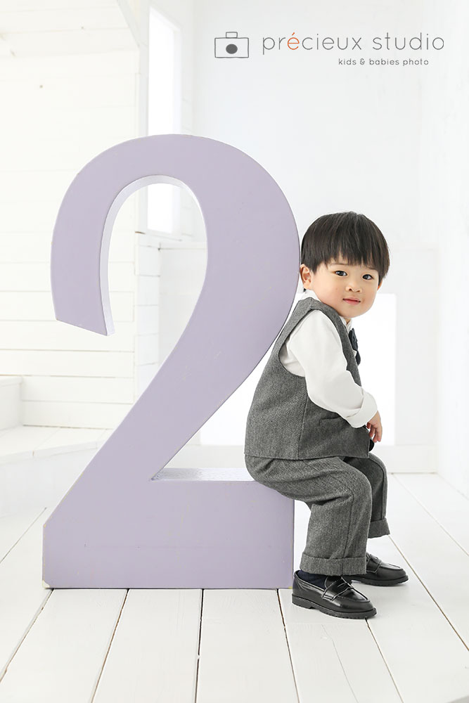紫色の大きな2のオブジェと一緒にバースデーフォト撮影の男の子