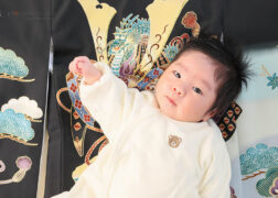 男の子のお宮参り記念写真撮影 黒い祝い着に寝転ぶ赤ちゃん