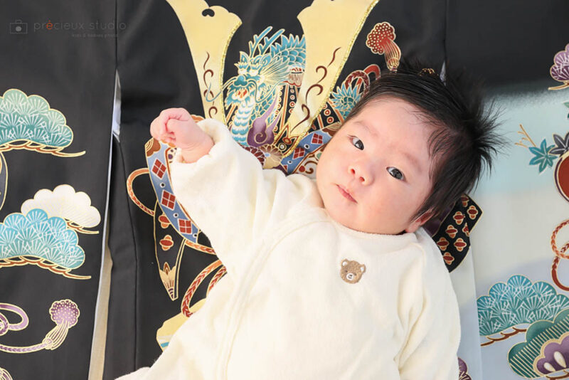 男の子のお宮参り記念写真撮影 黒い祝い着に寝転ぶ赤ちゃん